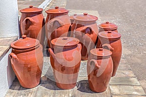 Several clay pots on floor outside pottery