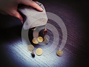 Several coins fall from an empty purse in a woman`s hand photo