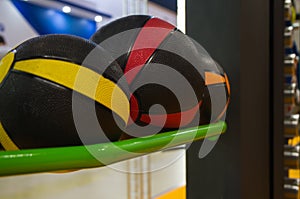 Several colored basketballs lying on the shelf in the gym for workouts