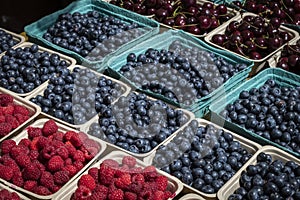 Several Containers Full of Fresh Blueberries, Raspberries and Cherries