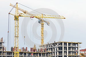 Several cranes and buildings against blue sky. Construction site of hightower structure. Abstract construction
