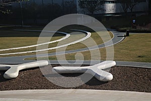 several curved park benches sitting on the ground in front of an office building