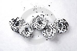 Several delicious fresh hearty black and white doughnuts lie on a white background. Jank food and high-calorie food