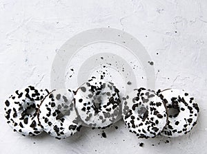 Several delicious fresh hearty black and white doughnuts lie on a white background. Jank food and high-calorie food