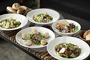 Several different fresh salad dishes on restaurant table