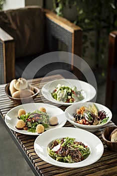 Several different fresh salad dishes on restaurant table