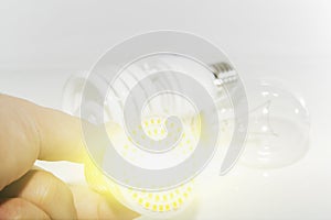Several different led bulbs and compact fluorescent lamps and the male hand on a light background.