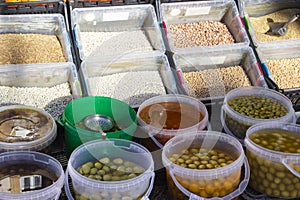 Several different types of olives in translucid cups at the street market