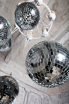 Several disco balls hanging under the ceiling - party decoration