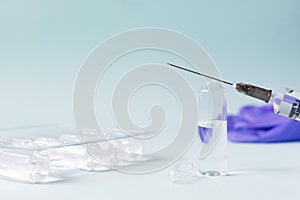 Several doses of vaccine and a syringe with medicine on a blue background. Vaccination. COVID-19, SARS - CoV2 Vaccine concept. photo