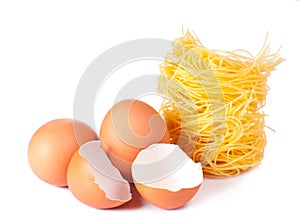Several eggs and pasta on a white