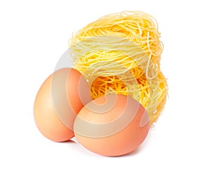 Several eggs and pasta on a white