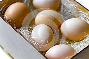 Several eggs in a wooden crate