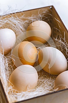 Several eggs in a wooden crate