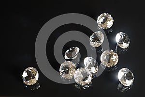 Several excellent pure diamonds with reflection on black mirror background close up view. Jewelry diamonds sale, invitation,