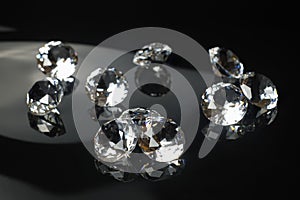 Several excellent pure diamonds with reflection on black mirror background close up view selective focus. Jewelry diamonds sale,