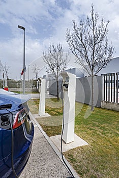 Several fast charging stations for electric vehicles in an open-air car park