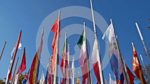 Several flagpoles with many flags in the wind