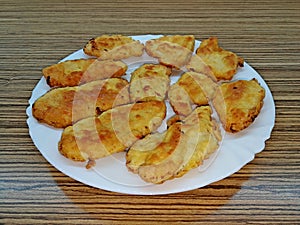 Several fried meat cutlets laid on a white porcelain plate