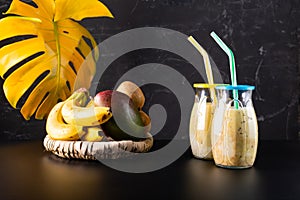 Several fruit cocktails. Cocktails and fruits on a black background. Two glasses with a cocktail