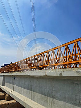 Several girders are arranged below yellow launcher gantry