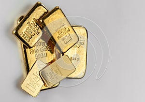 Several gold bars of different weights on a gray