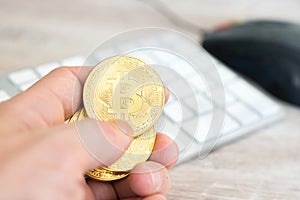Several golden bitcoins in a hand