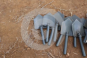 Several gray iron shovels placed on the background of the soil. Copy space