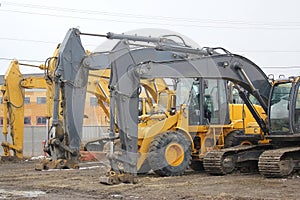 Several heavy construction vehicles, including excavators, diggers, earthmovers, and bulldozers