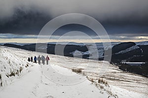 Several hikers in stormy winter landscape in Brecon Beacons
