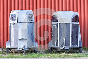 Several horse transportation trailers parked on the grass