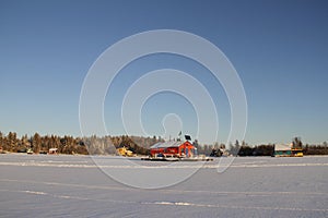 Several houseboats on Yellowknife Bay in Great Slave Lake with a red houseboat in the middle of the frame