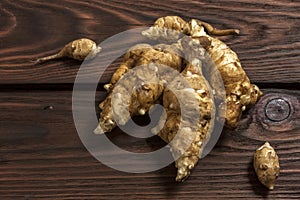 Several Jerusalem artichoke tubers on a wooden table. Helianthus tuberosus. Close up