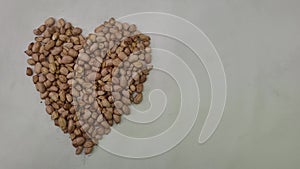 Several kernels with peanut shell forming a heart