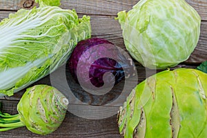 Several kinds of cabbage on rustic wooden table. Top view