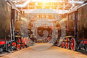 Several locomotives old steam vintage the railroad depot on repair maintenance service.