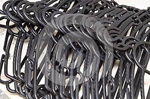 Several many numerous plastic black clothes hangers laid out