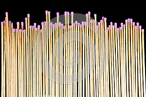 Several matchsticks lined up on black background photo