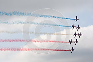 Several military aircraft releasing a multicolored smoke
