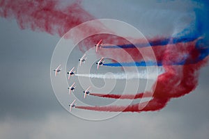 Several military aircraft symmetrically perform aerobatics