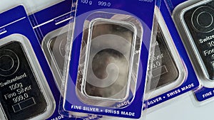 Several minted silver bars weighing 100 grams in transparent blister