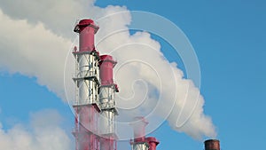 Several modern smoking chimneys on blue sky