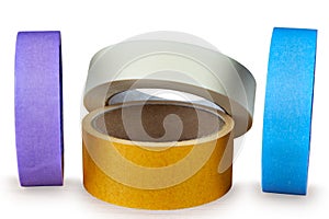 Several multi-colored rolls of adhesive tape on an white background.