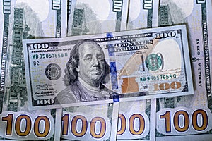 Several new hundred dollar bills lying close up.