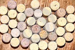 Several old wine corks stand on wooden background top