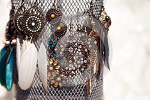 Several pairs of bronze colored vintage earrings on a jewelry stand at the market