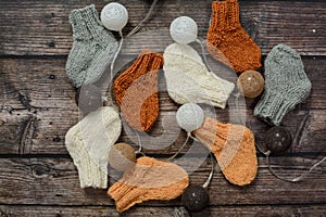 Several pairs of handmade baby socks on wooden background