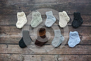 Several pairs of handmade baby socks on wooden background