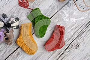 Several pairs of small woolen socks for newborn on wooden vintage table