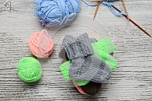 Several pairs of small woolen socks for newborn on wooden vintage table